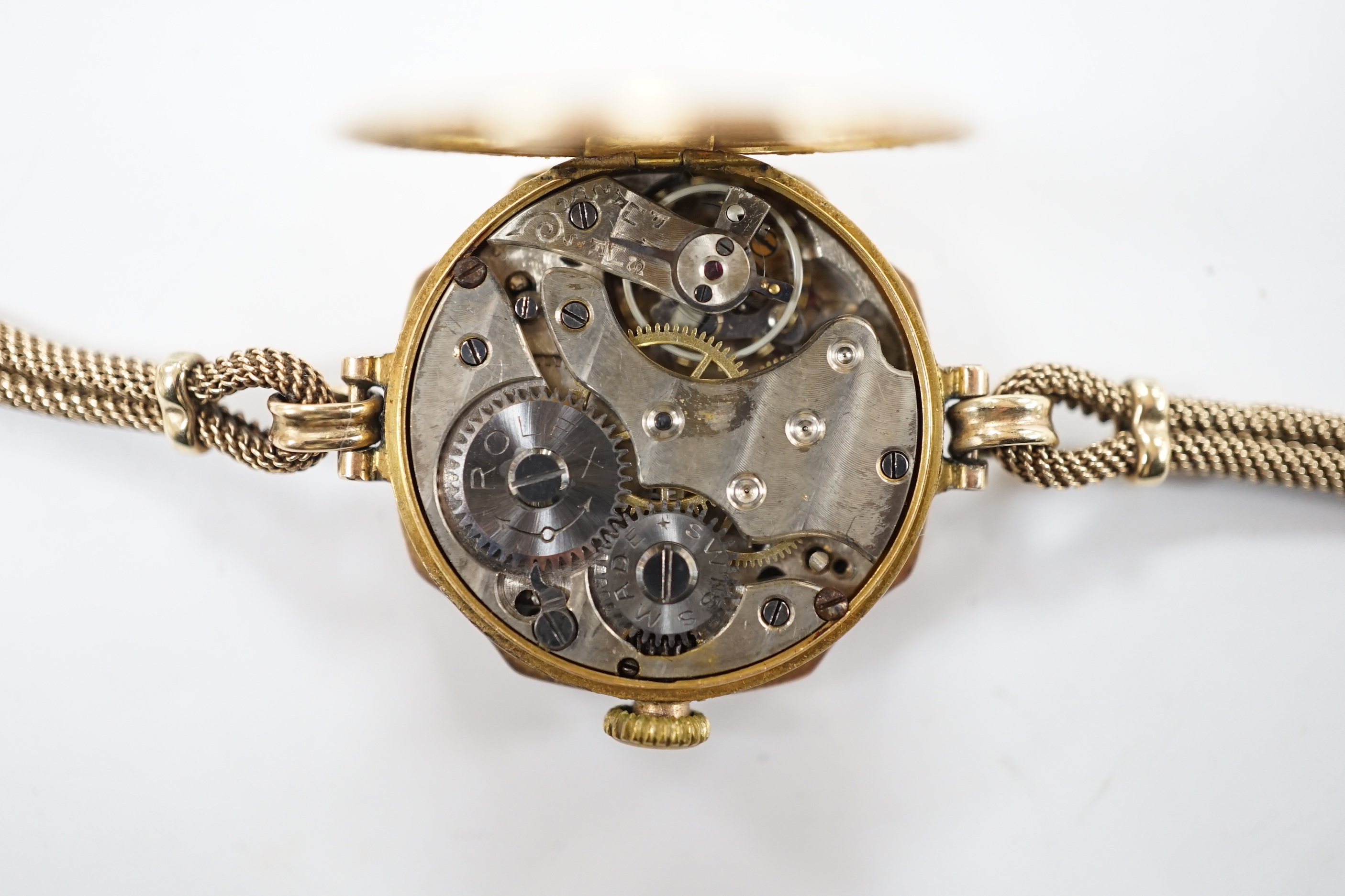 A lady's 1920's 9ct gold Rolex manual wind wrist watch, with sunburst Arabic dial, on a 9ct twin strand Vertex bracelet, gross weight 18.8 grams.